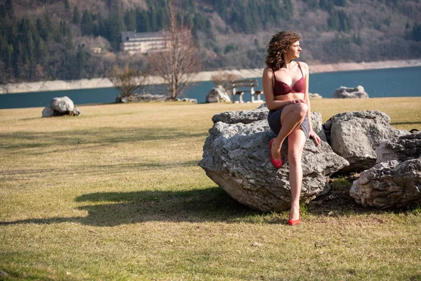 Сексуальная Девушка Черной Юбке Красный Лифчик Сидящий Скале Горного Озера — стоковое фото