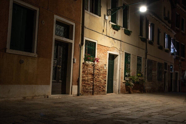 Ночная фотография типичных домов с окнами и дверями в Венеции, Италия. Волшебная атмосфера огней ночью
.