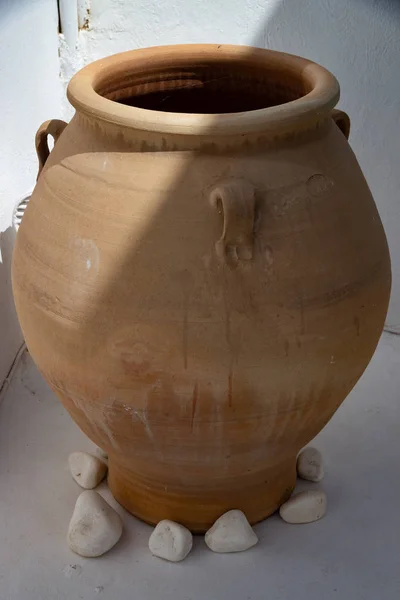 Ancient Greek ceramic earthenware vase placed on the entrance patio of a house. Elegant brown in color for the Mediterranean garden furnishings.