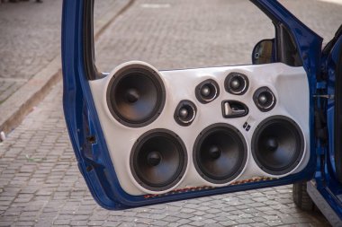 Set of eight speakers installed on a car door. Custom cars with large car stereo system speakers to the car show. clipart