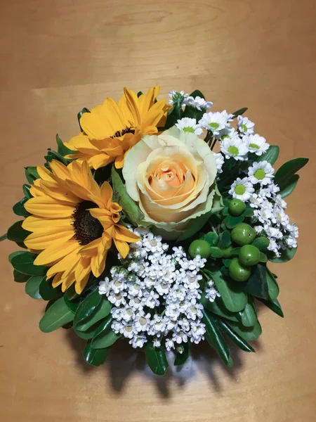 Centerpiece flower bouquet. With sunflower, rose, olives, daisies and green leaves.