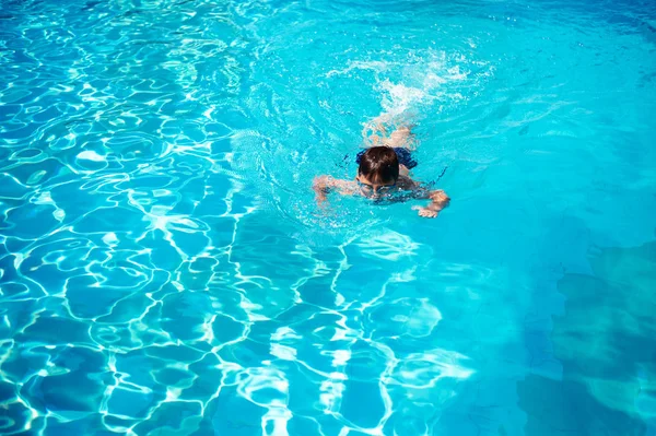 Ребенок плавает в бассейне отеля. Вид сверху . — стоковое фото