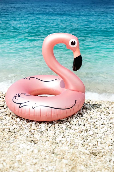 Гигантский надутый фламинго на пляже с бирюзовой водой Ионического моря Албании — стоковое фото