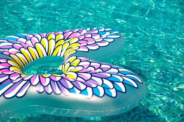 Разноцветная надутая бабочка, плавающая в освежающем голубом бассейне — стоковое фото