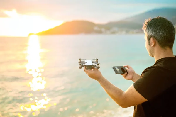 Young hipster man with flying drone.