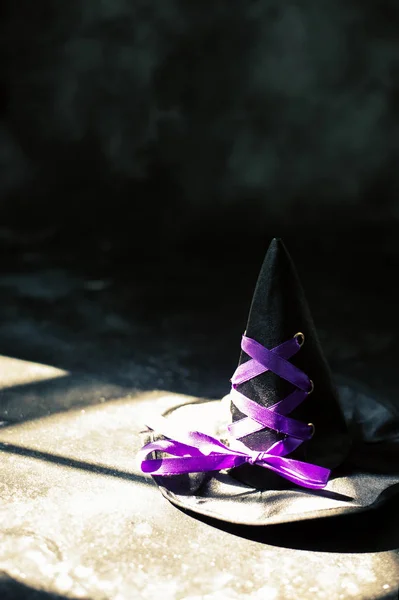 Sombrero de bruja sobre mesa oscura. Halloween concepto de vacaciones —  Fotos de Stock