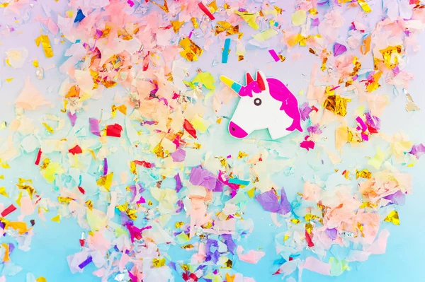 Een witte Eenhoorn met hoorn en confetti bovenaanzicht van de regenboog. — Stockfoto