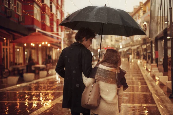 Pareja enamorada en la calle en un día lluvioso. Amigos caminando por la calle —  Fotos de Stock