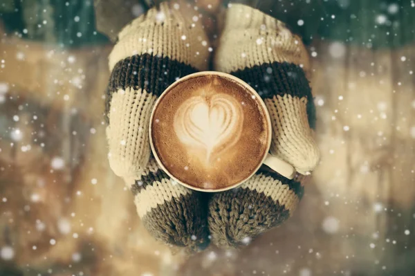 Vrouw handen in warme wollen wanten omarmen van warme koffiemok — Stockfoto