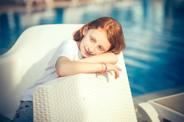 स्मित सुंदर लहान मुलगी सनी दिवशी पूल बसून . — स्टॉक फोटो, इमेज