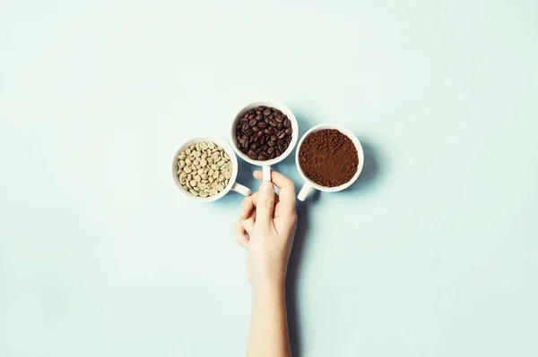 Jenis kopi yang berbeda - tanah, biji-bijian dan tidak dipanggang di latar belakang pastel biru — Stok Foto