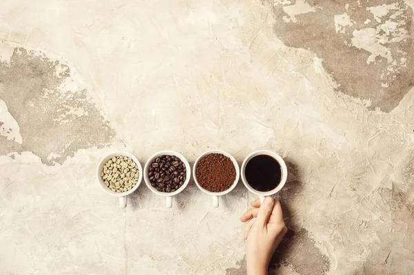 four types of coffee unroasted, bean, ground and one in cup