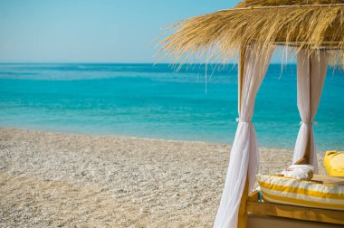 Tente şemsiye ve şezlonglar güzel plajda Himara, Arnavutluk.