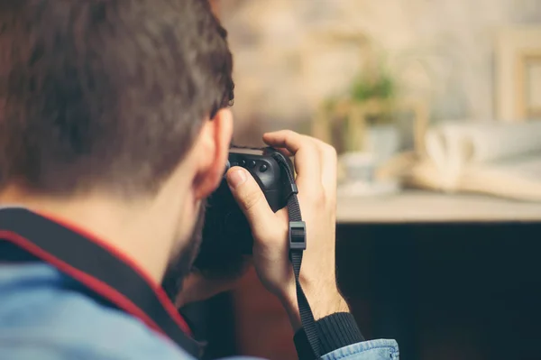 Câmera DSLR em mãos de fotógrafos jovens atirando objetos em estúdio de fotos indoor — Fotografia de Stock