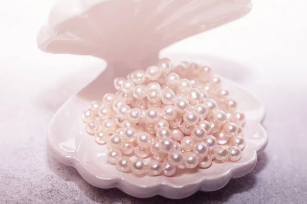 Collar de perlas en un fondo blanco de concha — Foto de Stock