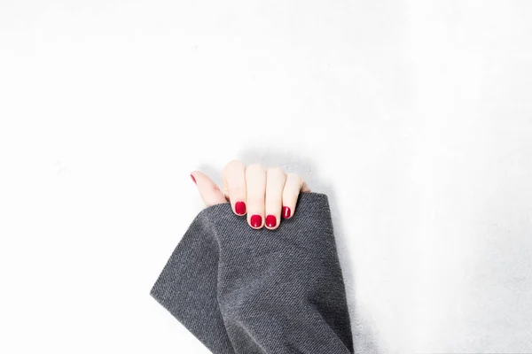 Primer plano de las manos de una joven con manicura de color rojo oscuro en las uñas sobre fondo blanco — Foto de Stock