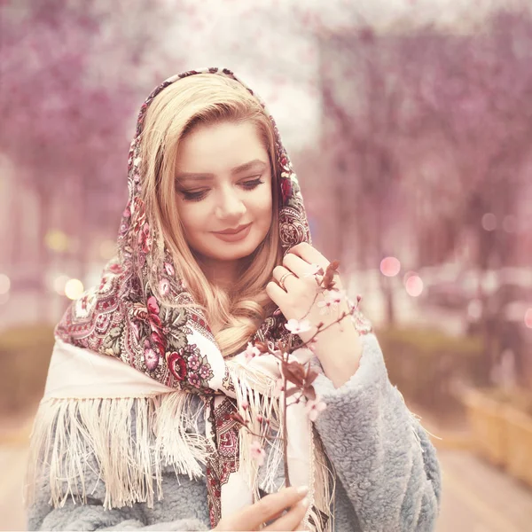 Retrato de una hermosa joven con un vestido vintage en la calle floreciente . — Foto de Stock