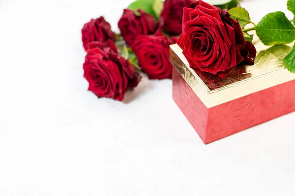 Κουτί δώρου, άνθη τριαντάφυλλου και διακοσμητικές καρδιές σε λευκό φόντο — Φωτογραφία Αρχείου