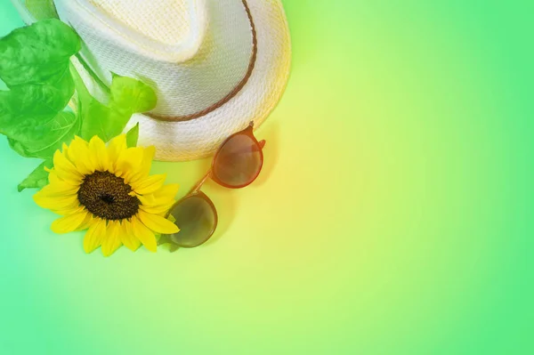 Модный плоский плащ с солнцезащитными очками, соломенной шляпой и ярко-желтым подсолнухом — стоковое фото