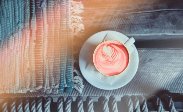 Kopp färsk arom korall färg cappuccino med vacker latte konst hjärta på trä bakgrund — Stockfoto