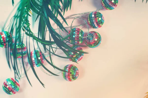 concept image of tropical winter holidays with felt christmas tree palm leaf and illumination lights