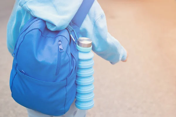 Wiederverwendbare umweltfreundliche Wasserflasche auf dem Kinderrucksack — Stockfoto