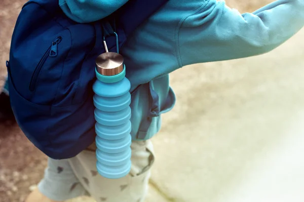 Wiederverwendbare umweltfreundliche Wasserflasche auf dem Kinderrucksack — Stockfoto