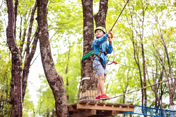 Joven chico pasando la ruta del cable entre los árboles, el deporte extremo en el parque de aventuras — Foto de Stock