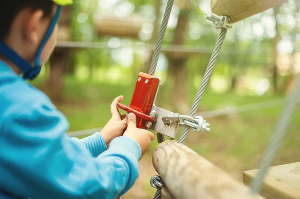 Giovane ragazzo che passa via cavo tra gli alberi, sport estremo nel parco avventura — Foto Stock