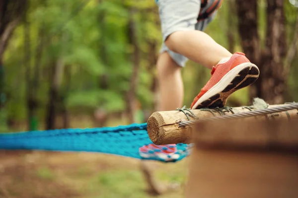 Giovane ragazzo che passa via cavo tra gli alberi, sport estremo nel parco avventura — Foto Stock