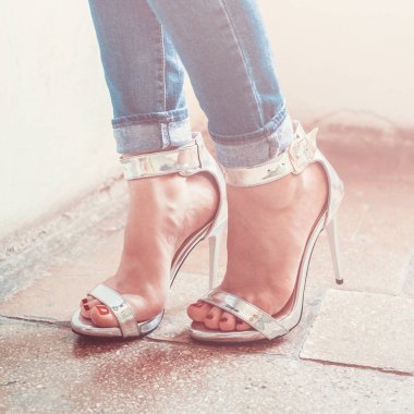 Woman wearing jeans and high heel shoes in old building