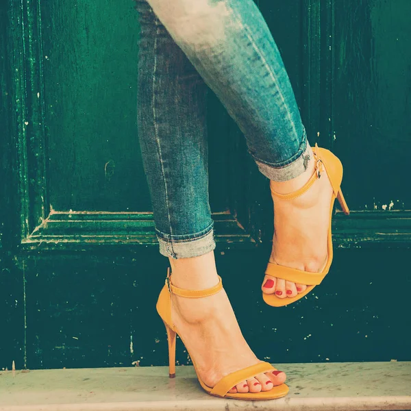 Woman wearing jeans and high heel shoes in old building — Stockfoto