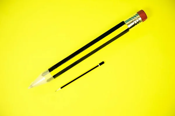 Um lápis gigante e um pequeno lápis comum — Fotografia de Stock