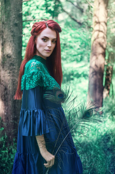 Female portrait with peacock feather on foreground. beauty makeup.