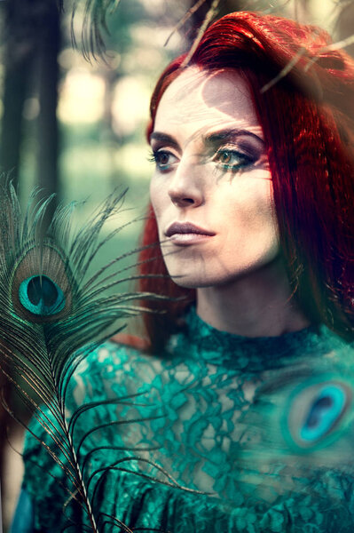 Female portrait with peacock feather on foreground. beauty makeup.