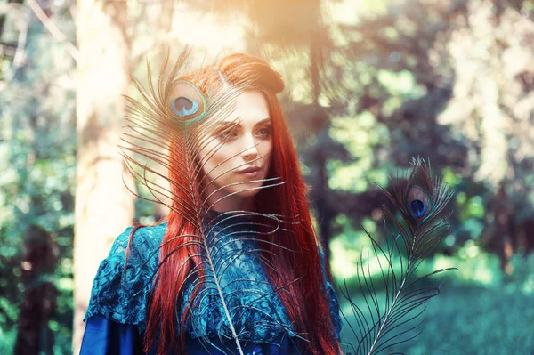 Retrato femenino con pluma de pavo real en primer plano. maquillaje de belleza . — Foto de Stock