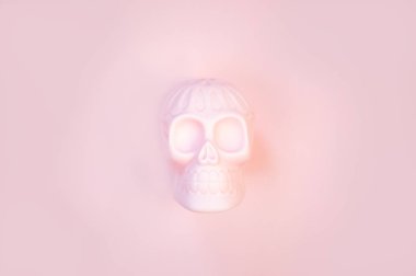 Metin için boş alan ile pastel arka plan üzerinde Halloween insan pembe kafatası.