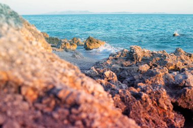 Arnavutluk'ta İyon Denizi'nin kayalık plajı ve kristal turkuaz suyu. Sakin ve dinlendirici manzara