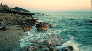 Arnavutluk'ta İyon Denizi'nin kayalık plajı ve kristal turkuaz suyu. Sakin ve dinlendirici manzara