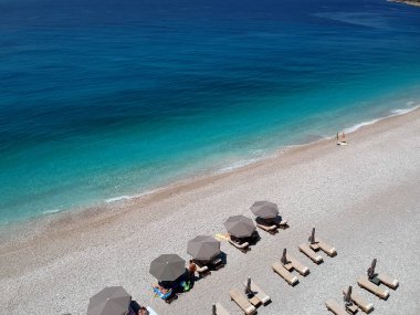 Arnavutluk'ta İyon Denizi'nin kayalık plajı ve kristal turkuaz suyu.