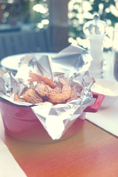 Heerlijke gebakken garnalen close-up en roomsaus op het perkament op tafel. — Stockfoto