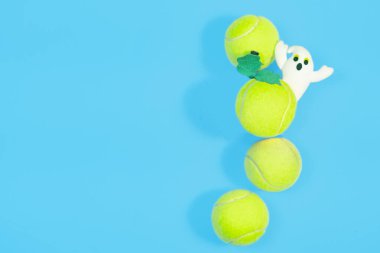 Mavi arka planda büyük bir tenis topu - Cadılar Bayramı minimal tasarım üst görünümü
