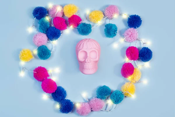 Halloween humano rosa crânio colorido tricotado bolas guirlanda no fundo pastel — Fotografia de Stock