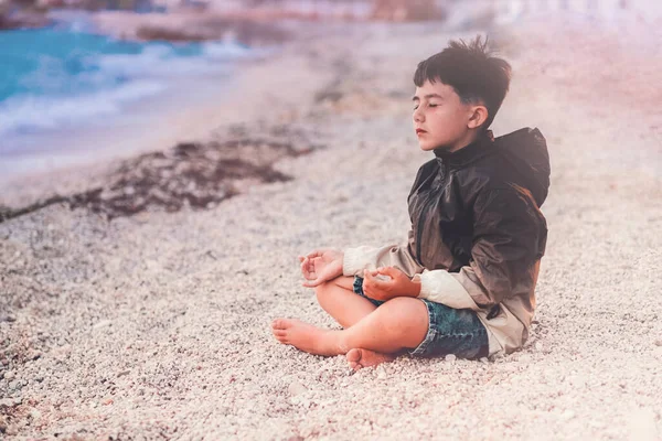 Kind meditiert am Strand — Stockfoto