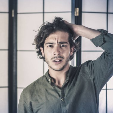 Genç adamın kafasına korkuyla elleriyle yakın çekim