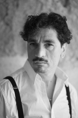 Duvara yaslanmış bıyıkları olan adam portresi