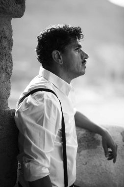 Duvara yaslanmış bıyıkları olan adam portresi