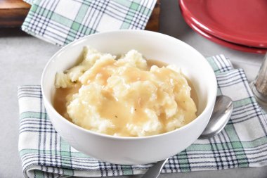 A serving bowl of mashed potatoes topped with chicken gravy clipart