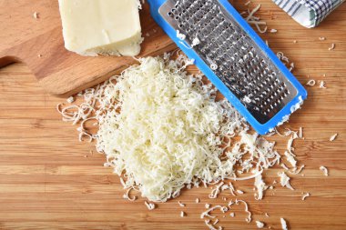 İnce rendelenmiş mozzarella peyniri havai görünümü bir kesme tahtası üzerinde
