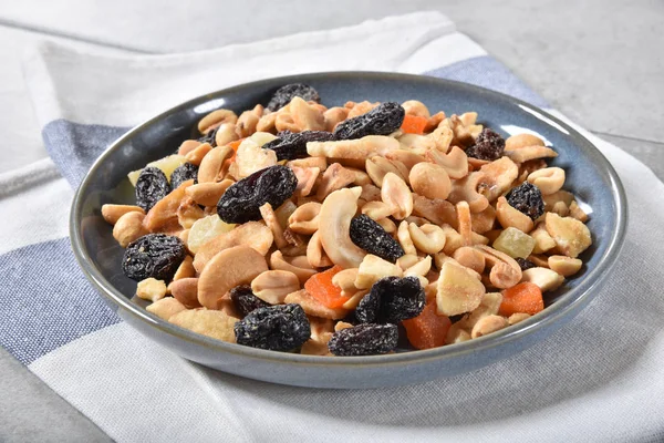 A small bowl of tropical trail mix on a napkin
